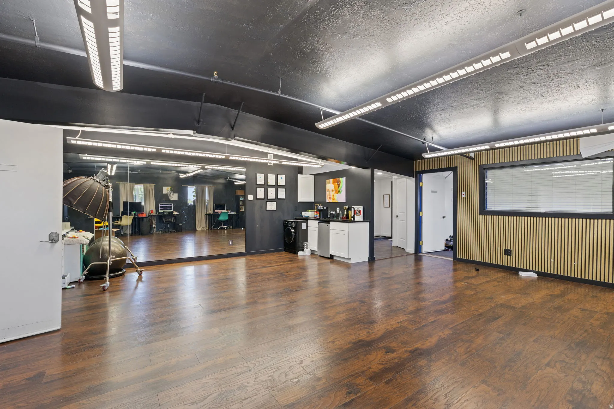 Spacious interior featuring wood-finish flooring, a full-wall mirror, and recessed linear lighting