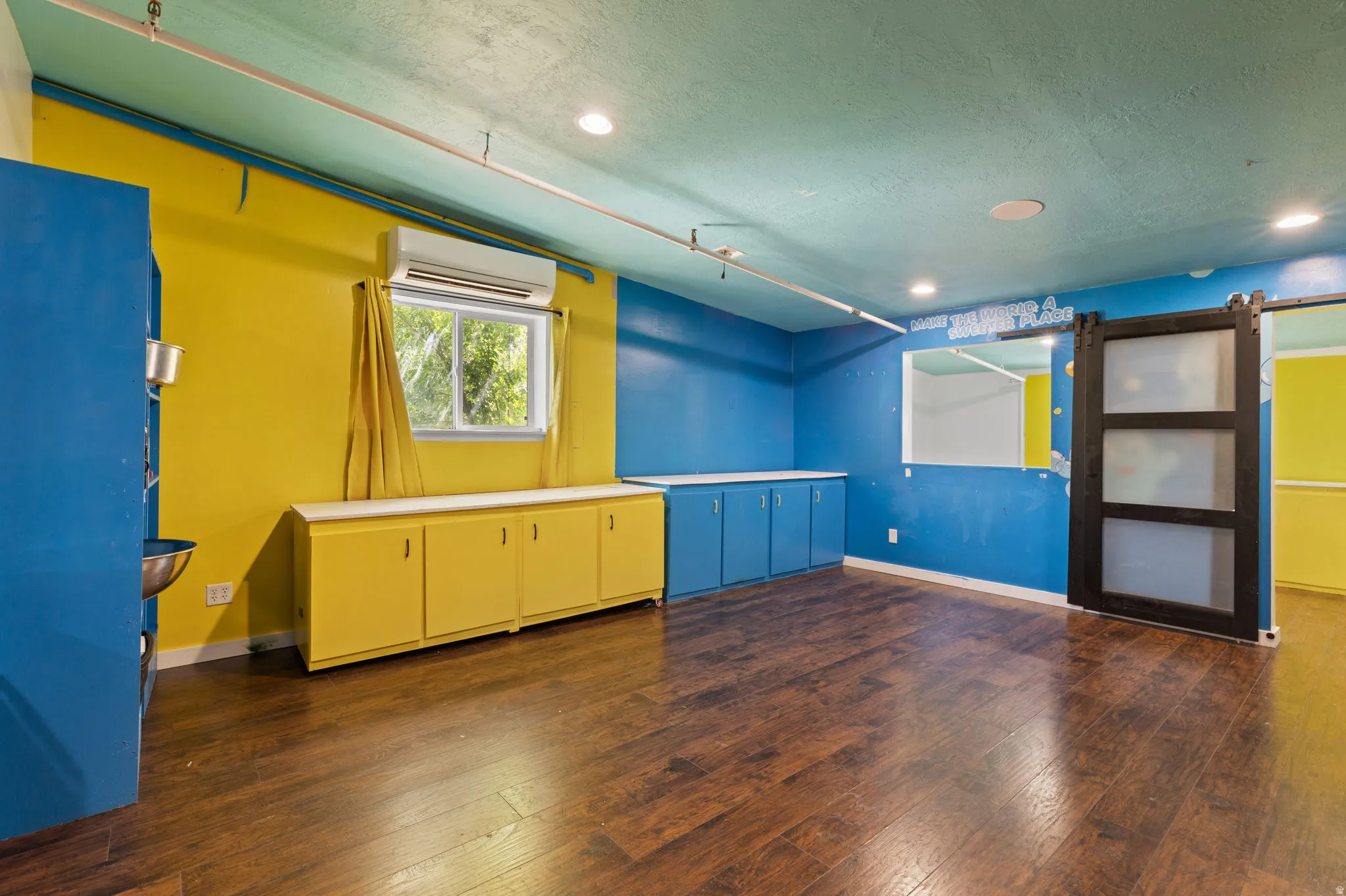 Spacious room featuring wood-finish flooring, recessed lighting, and built-in cabinetry with white countertops