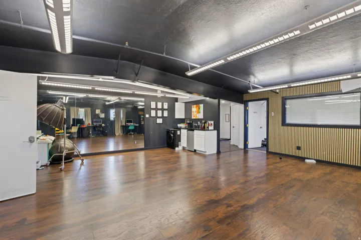 Spacious interior featuring wood-finish flooring, a full-wall mirror, and recessed linear lighting