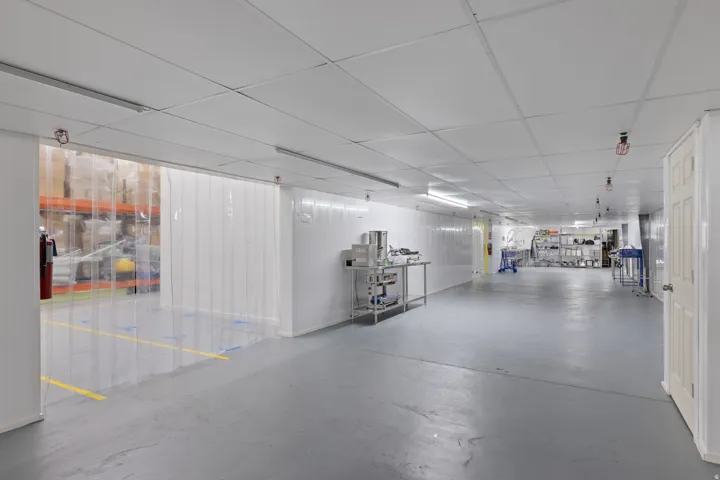Spacious commercial interior featuring resilient flooring, drop ceiling with integrated lighting, and multiple access points