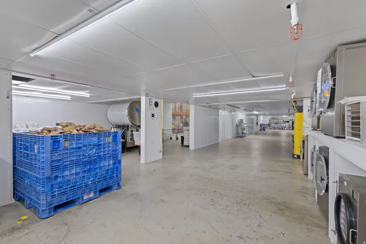 Spacious commercial interior featuring concrete flooring and a white panel ceiling