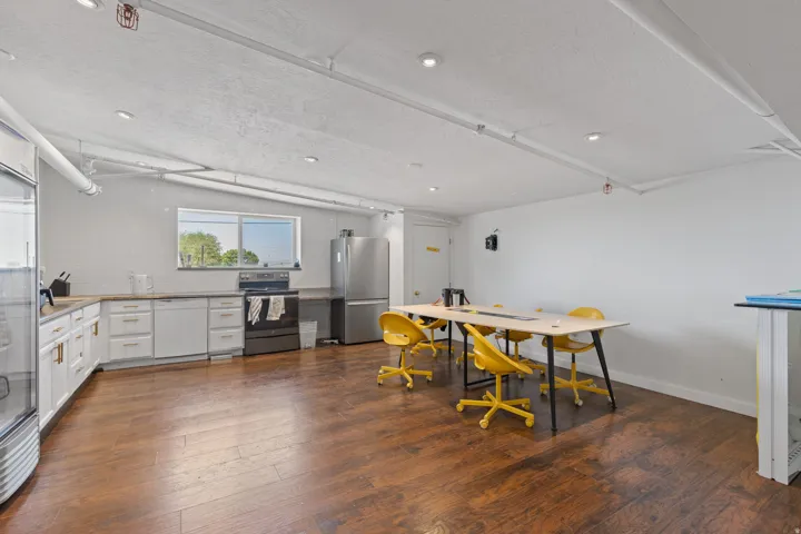 Expansive open-concept room featuring wood-finish flooring and recessed lighting