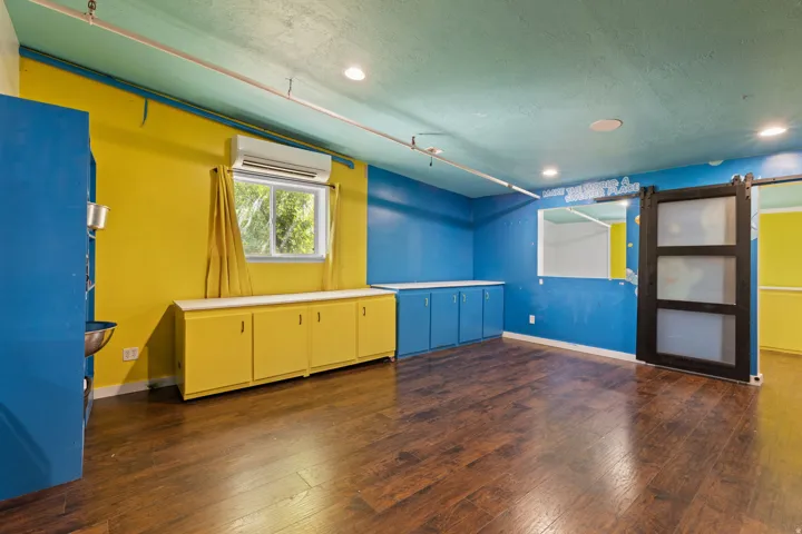 Spacious room featuring wood-finish flooring, recessed lighting, and built-in cabinetry with white countertops