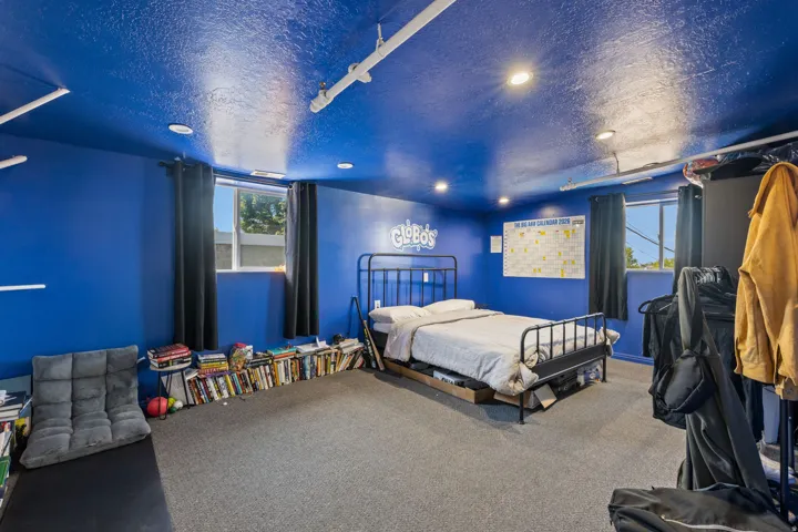 Carpeted room featuring recessed lighting, a window with dark curtains, and blue walls and ceiling