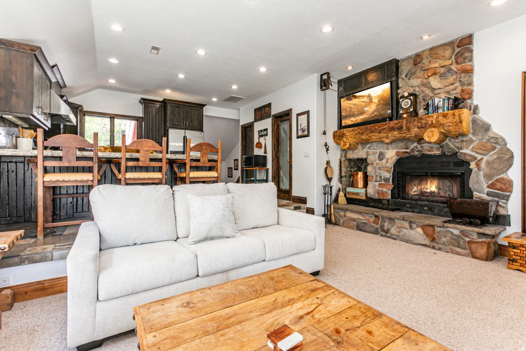Stone fireplace with a log mantel and integrated hearth