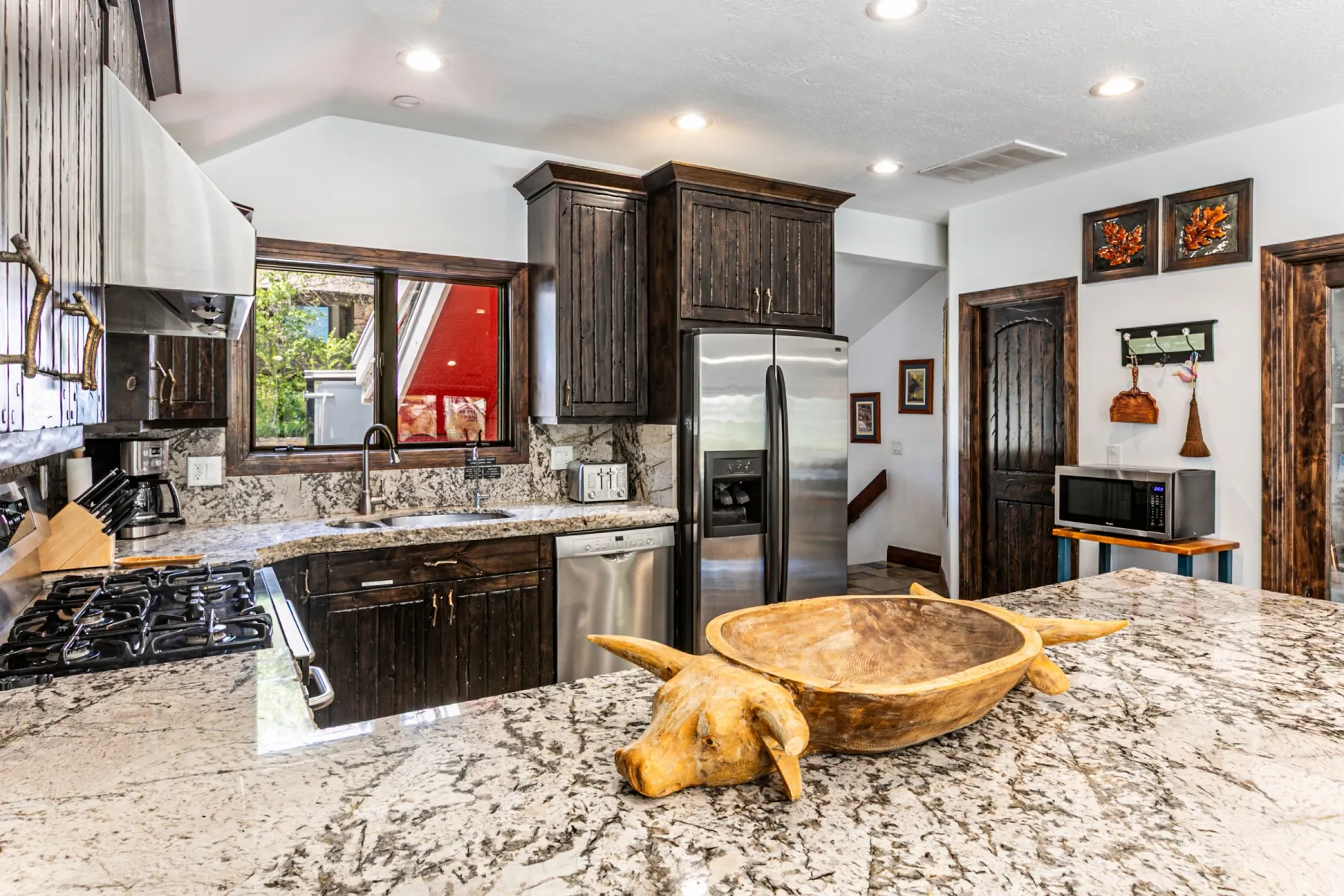 Kitchen featuring granite countertops, dark wood-finish cabinetry, stainless steel appliances, a gas range, and recessed lighting