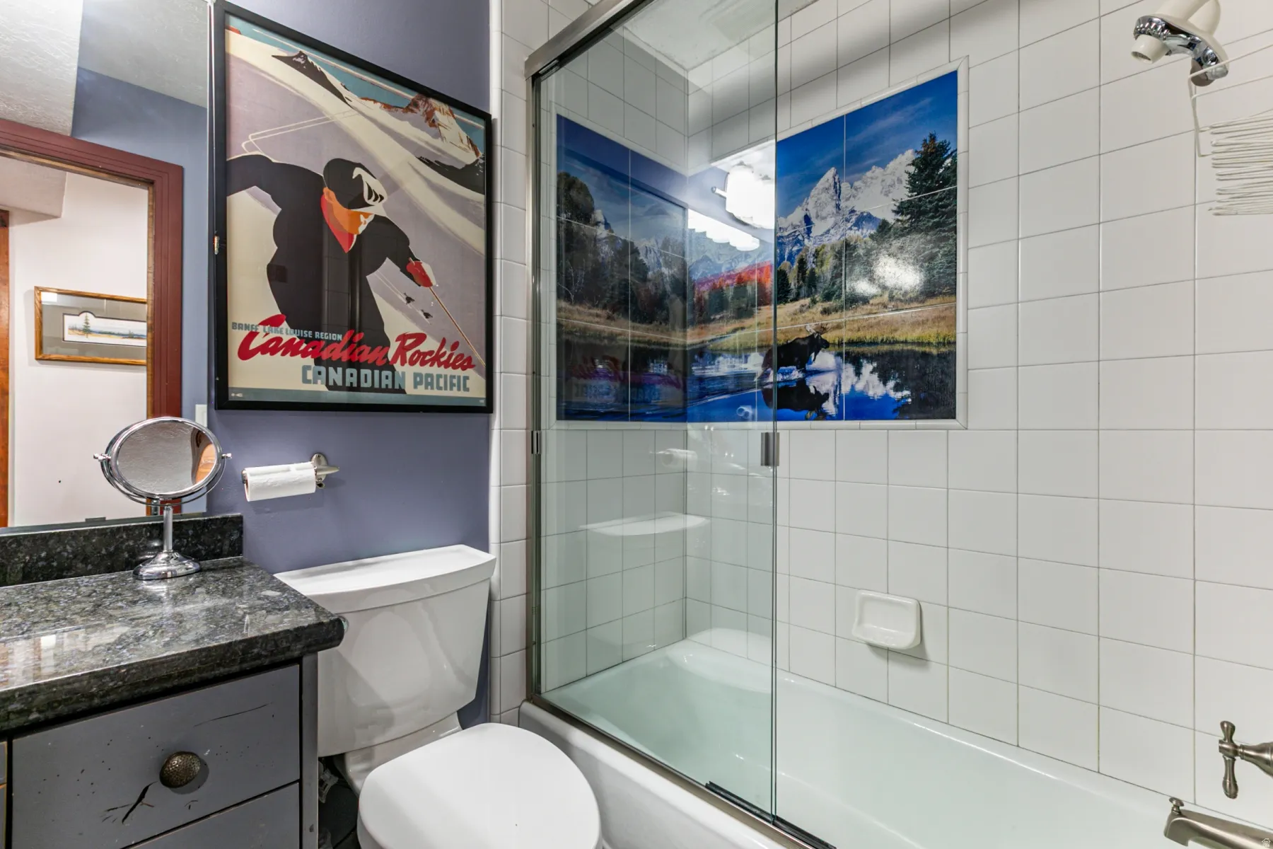 Bathroom featuring a shower-tub combination with clear glass enclosure and white tile surround