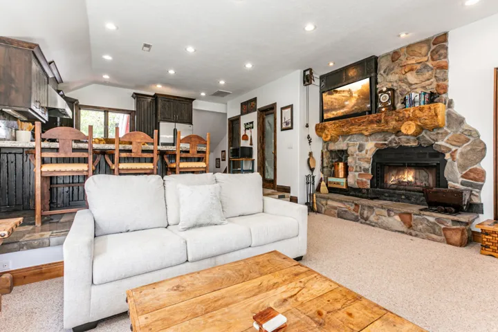 Stone fireplace with a log mantel and integrated hearth