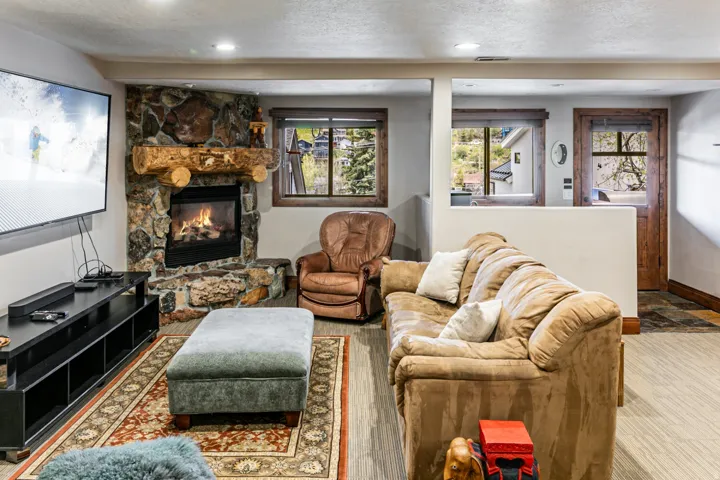 Stone-faced corner fireplace with a large log mantel