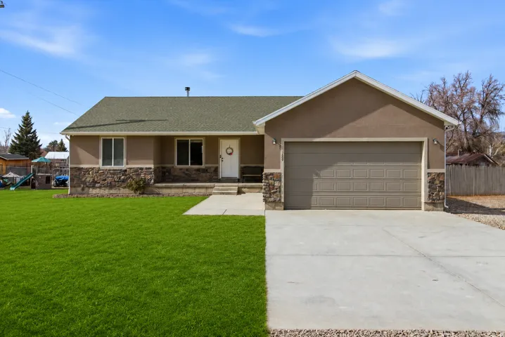 Contemporary ranch-style home featuring a stucco exterior with stone accents and a textured asphalt shingle roof