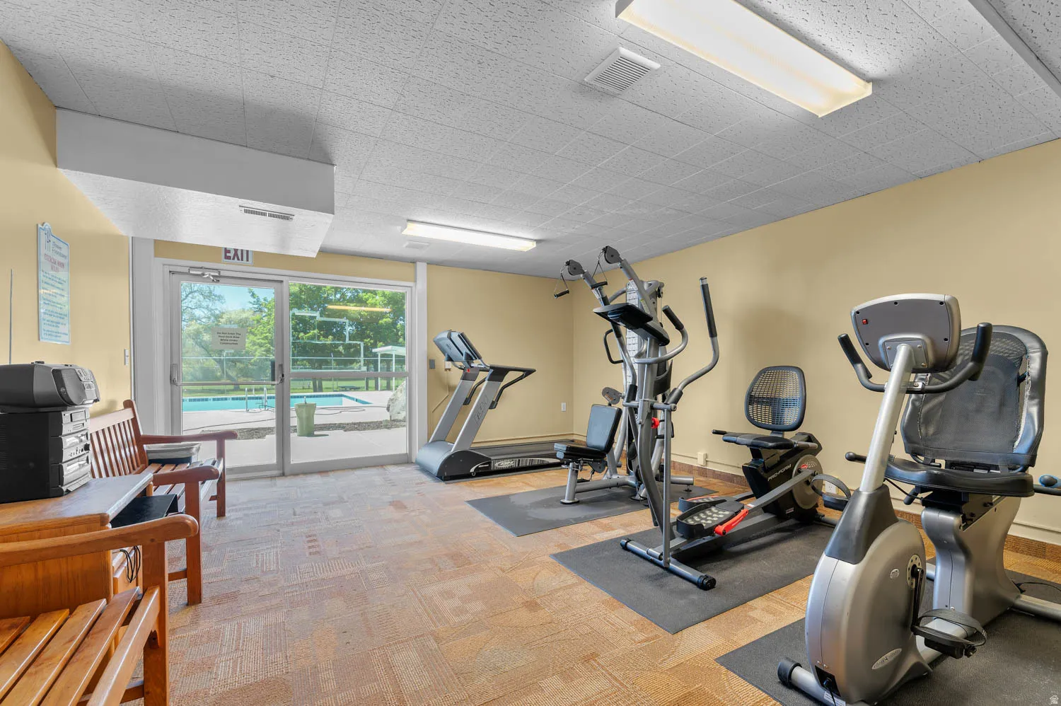 Club House Fitness room with neutral-toned walls, patterned carpet flooring, and recessed lighting