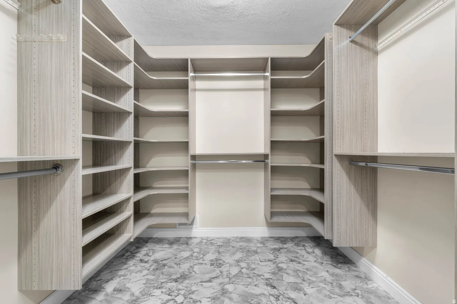 Custom closet system featuring light wood-finish shelving and hanging rods