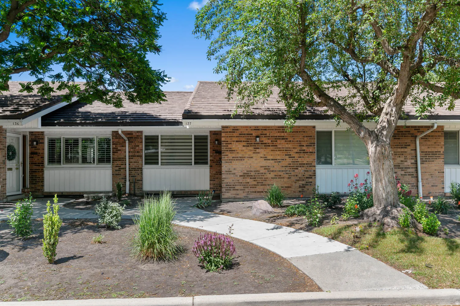 Brick exterior with white trim and a brown shingle roof