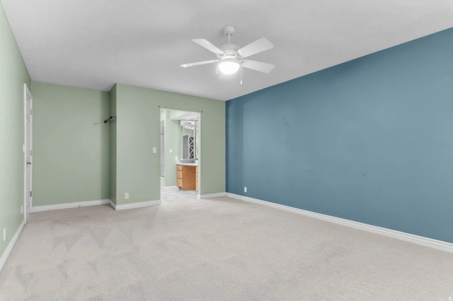 Spacious room featuring light-colored carpeting and a ceiling fan with integrated lighting