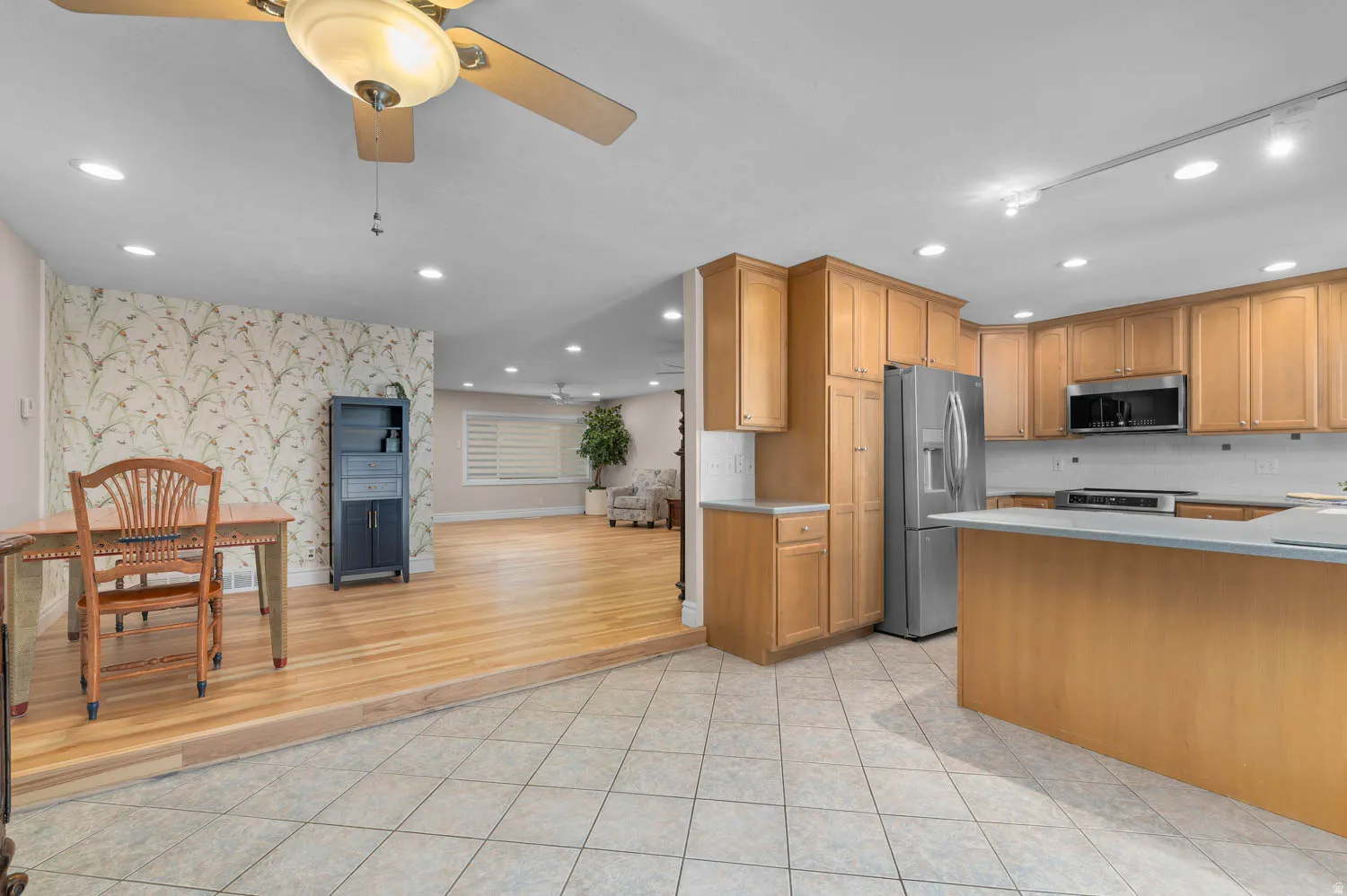 Kitchen featuring light wood cabinetry, stainless steel appliances, and a central island with a light countertop