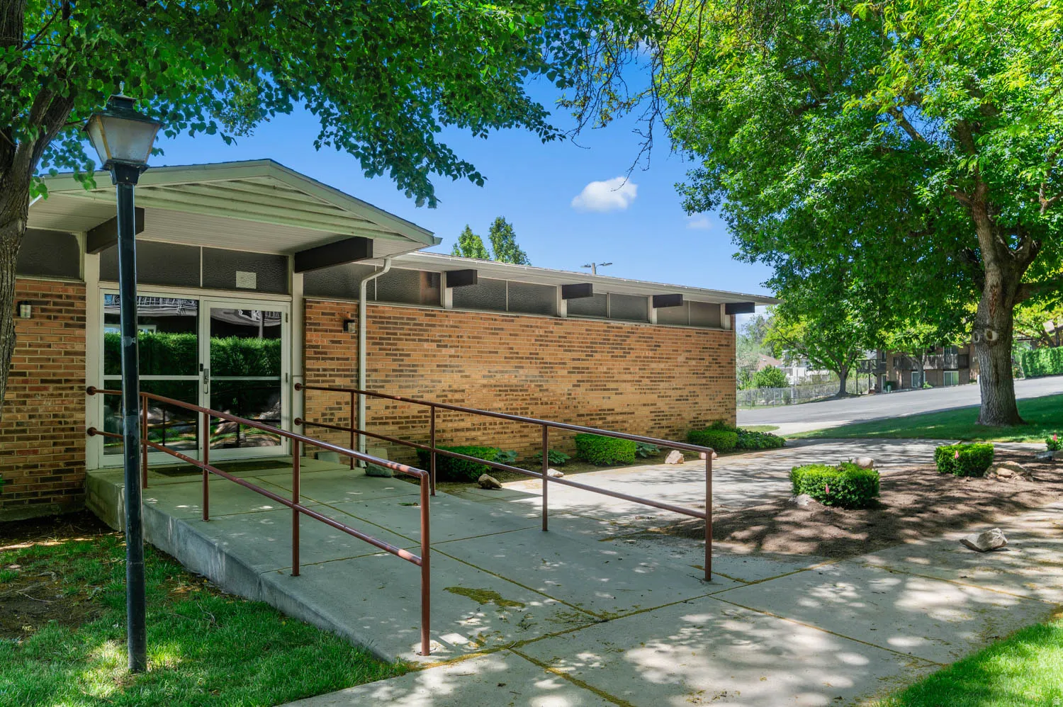 Brick exterior featuring a covered entryway with full-light glass doors and an ADA-compliant ramp