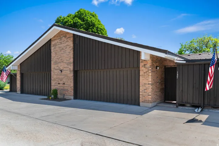 Contemporary exterior featuring brown vertical siding and brick accents