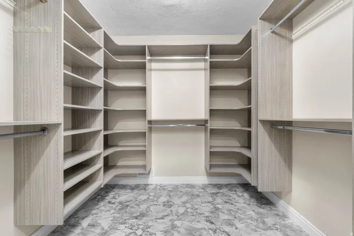 Custom closet system featuring light wood-finish shelving and hanging rods