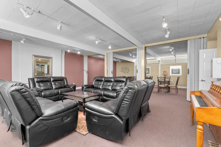 Club House Spacious common area featuring track lighting, dropped acoustic ceiling, and broadloom carpeting