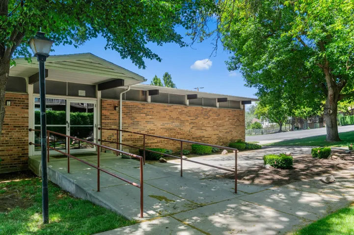 Brick exterior featuring a covered entryway with full-light glass doors and an ADA-compliant ramp