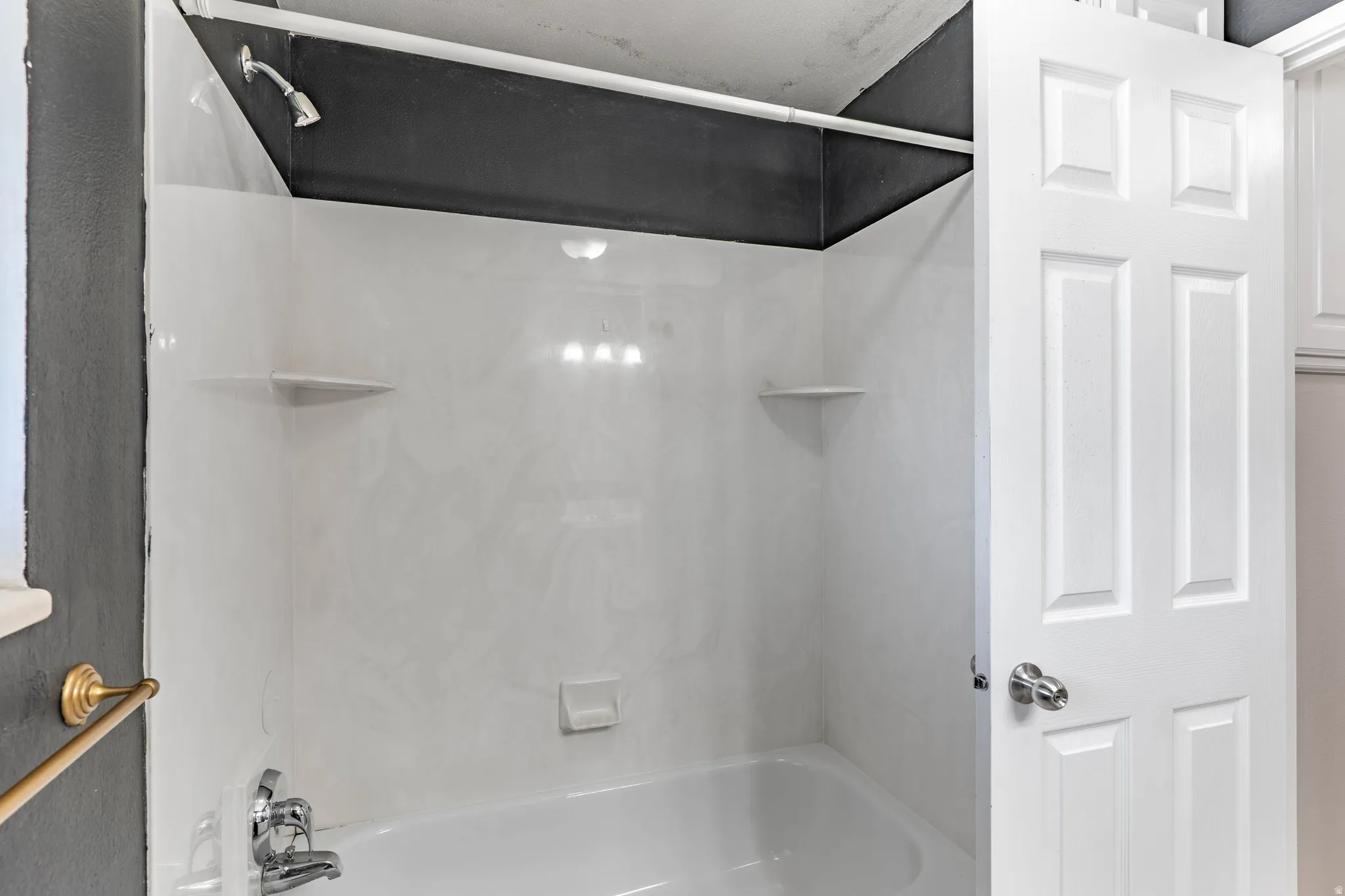 White tub and shower combination with integrated shelving