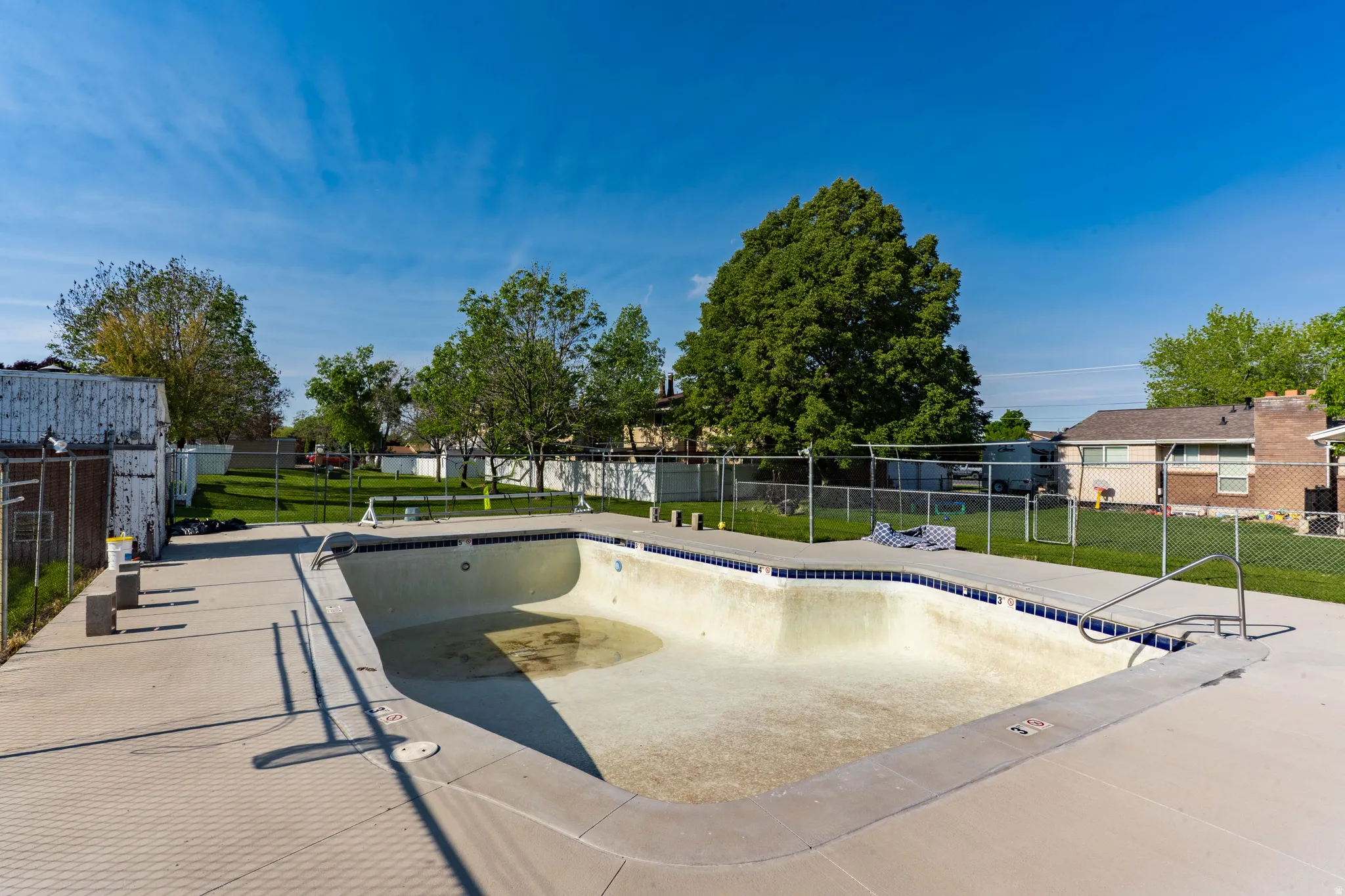 In-ground swimming pool with a concrete surround and integrated diving board