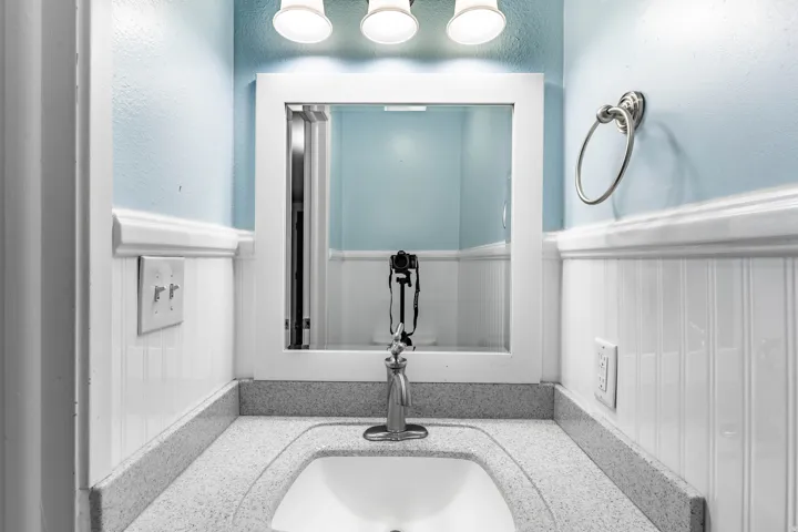 Bathroom vanity featuring a speckled countertop, integrated sink, and brushed nickel faucet