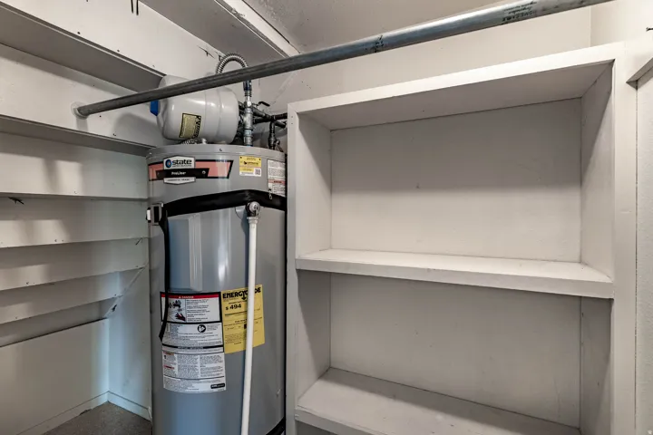 Water heater with an expansion tank and adjacent built-in shelving