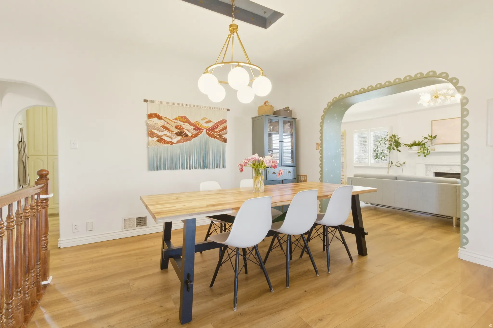 Hardwood-finish flooring throughout, featuring a decorative archway, recessed lighting, and a modern chandelier