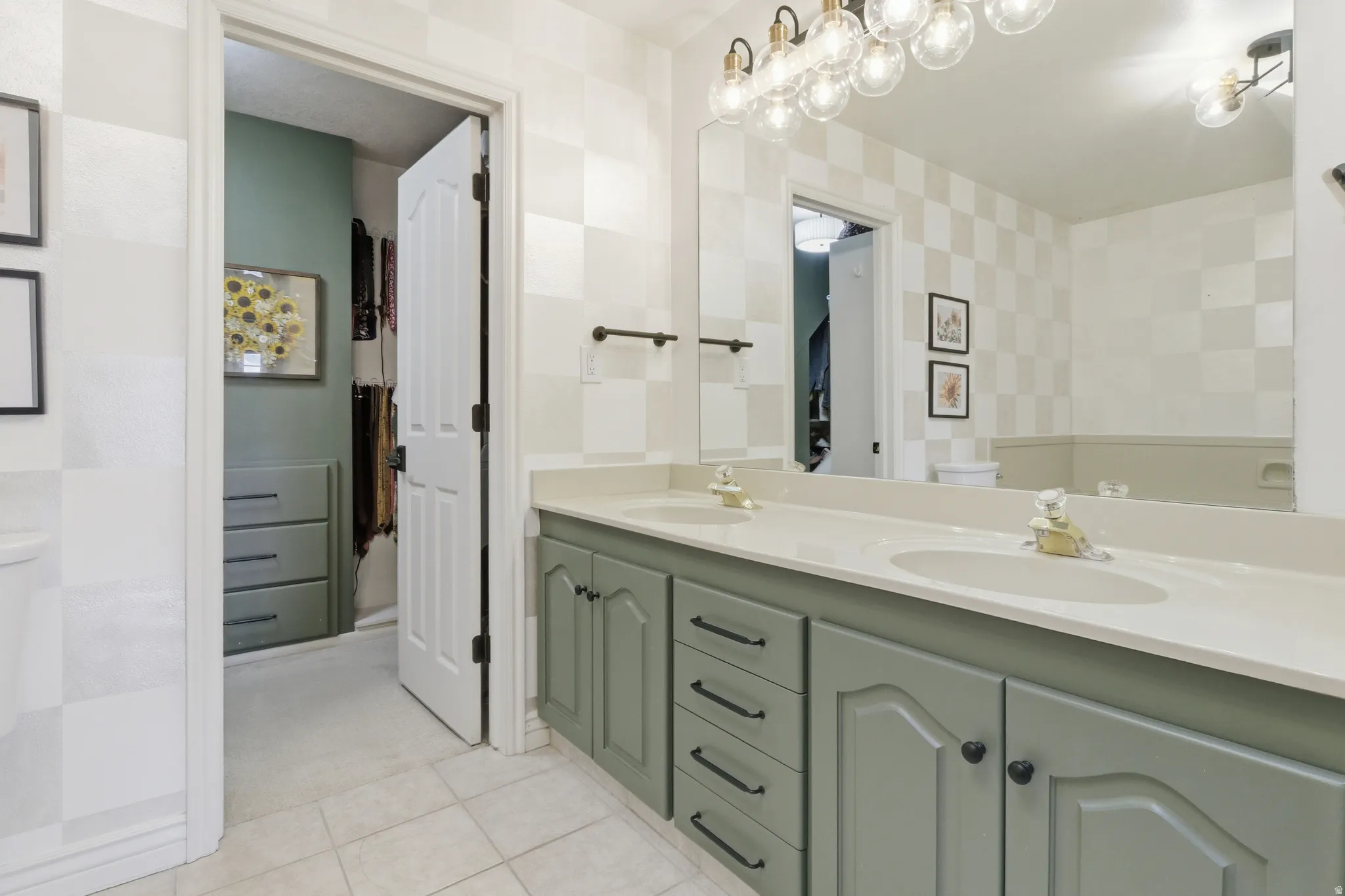 Double vanity with integrated sinks, light-toned countertop, and sage green cabinetry