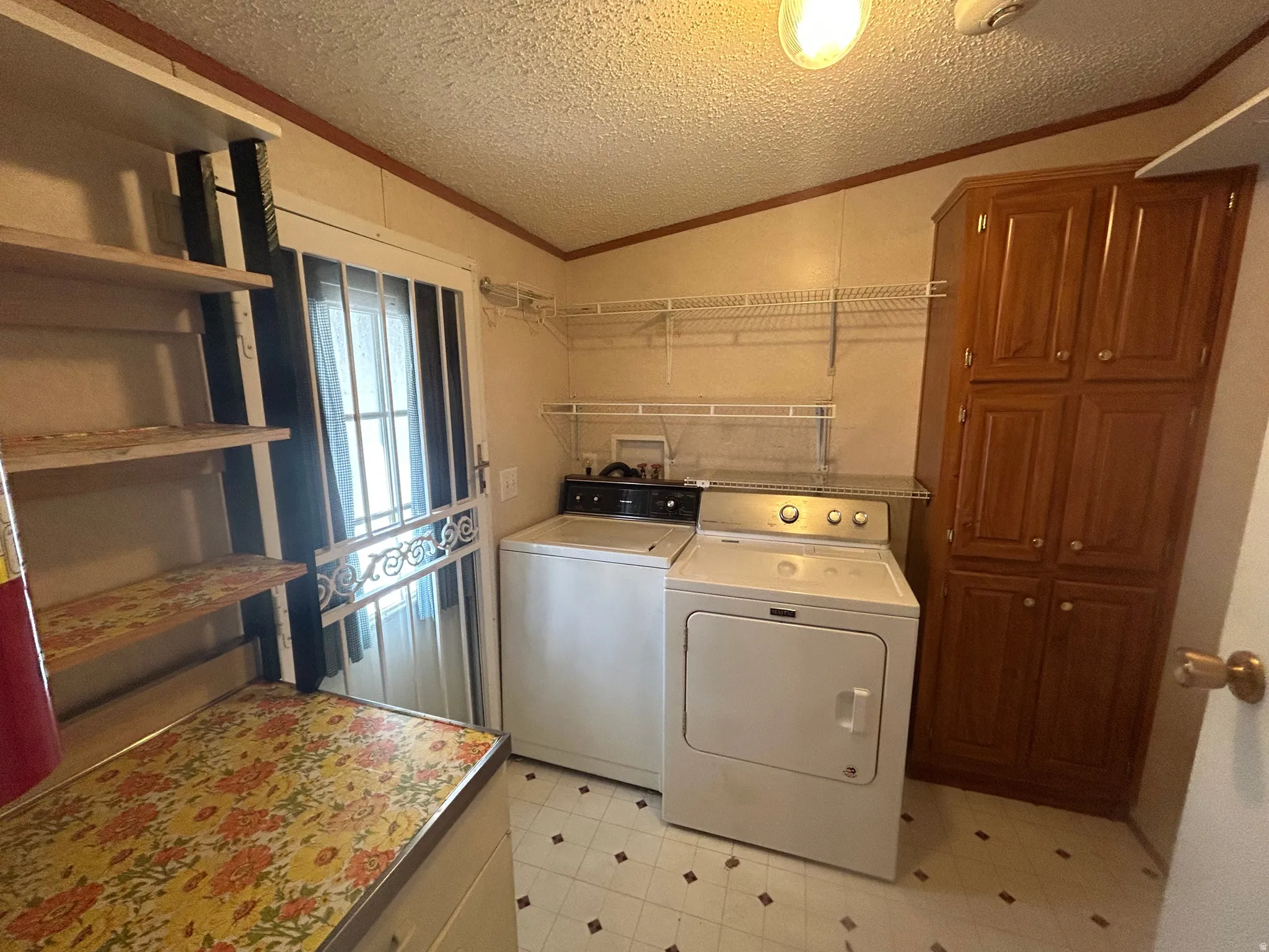 Dedicated utility room featuring patterned vinyl flooring, storage cabinet, and wire shelving