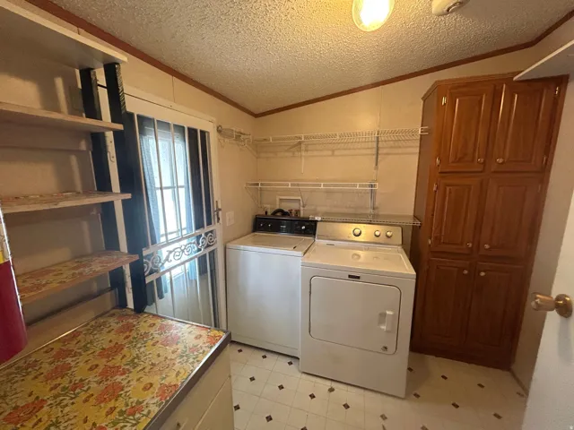 Dedicated utility room featuring patterned vinyl flooring, storage cabinet, and wire shelving