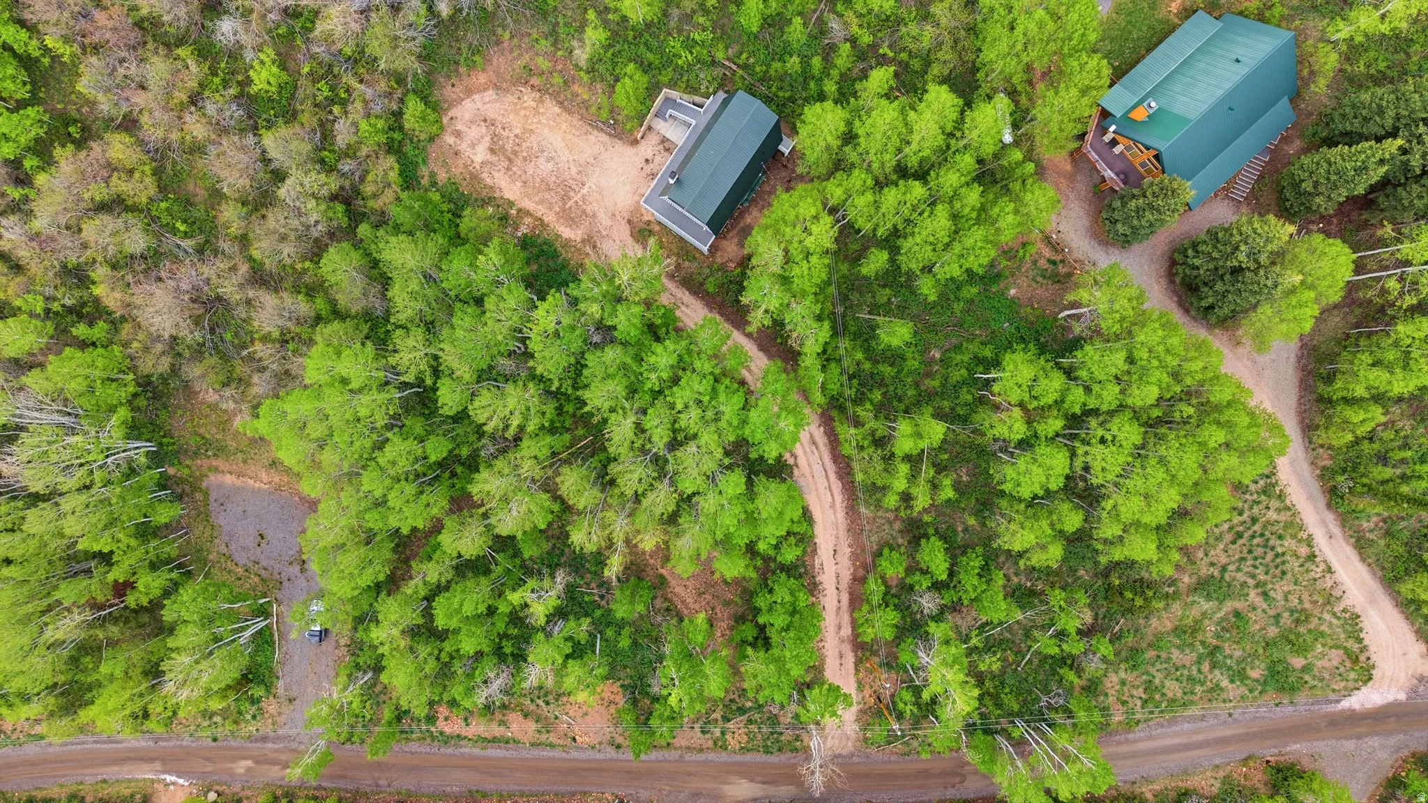 Property featuring two structures nestled among extensive natural foliage