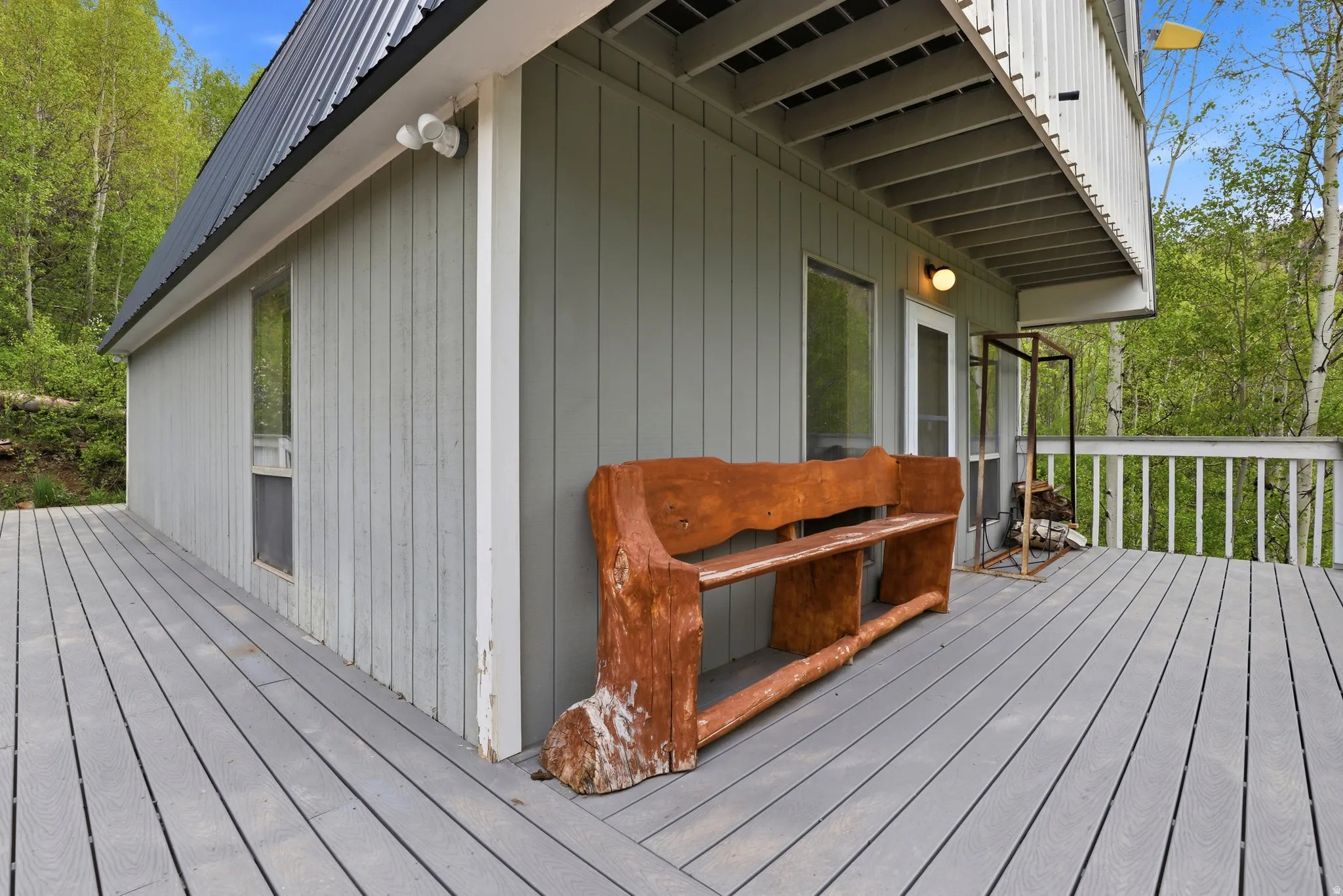 Spacious exterior deck with gray composite decking, white railings, and direct access to the interior