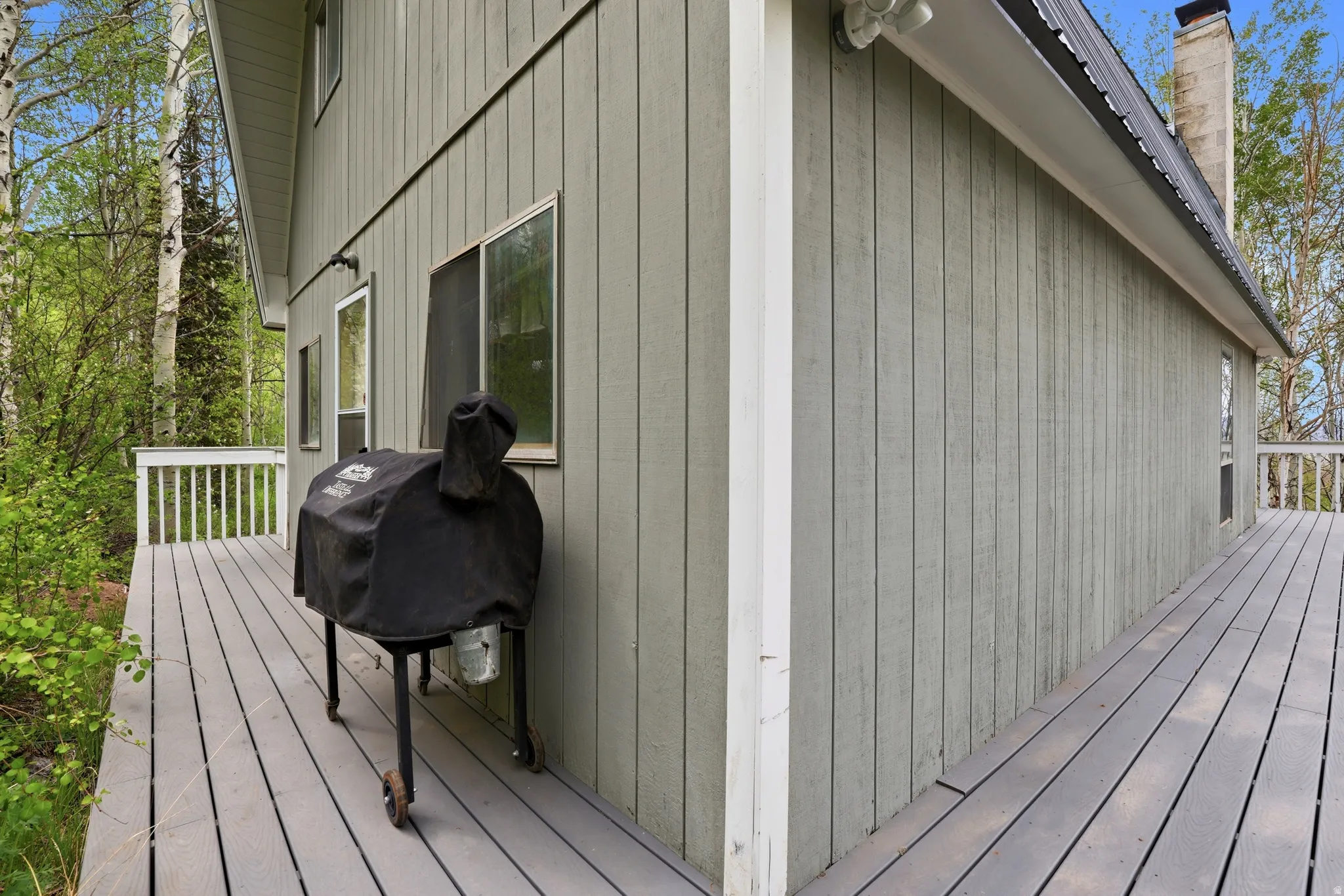 Expansive outdoor deck featuring wood-finish flooring and white railings