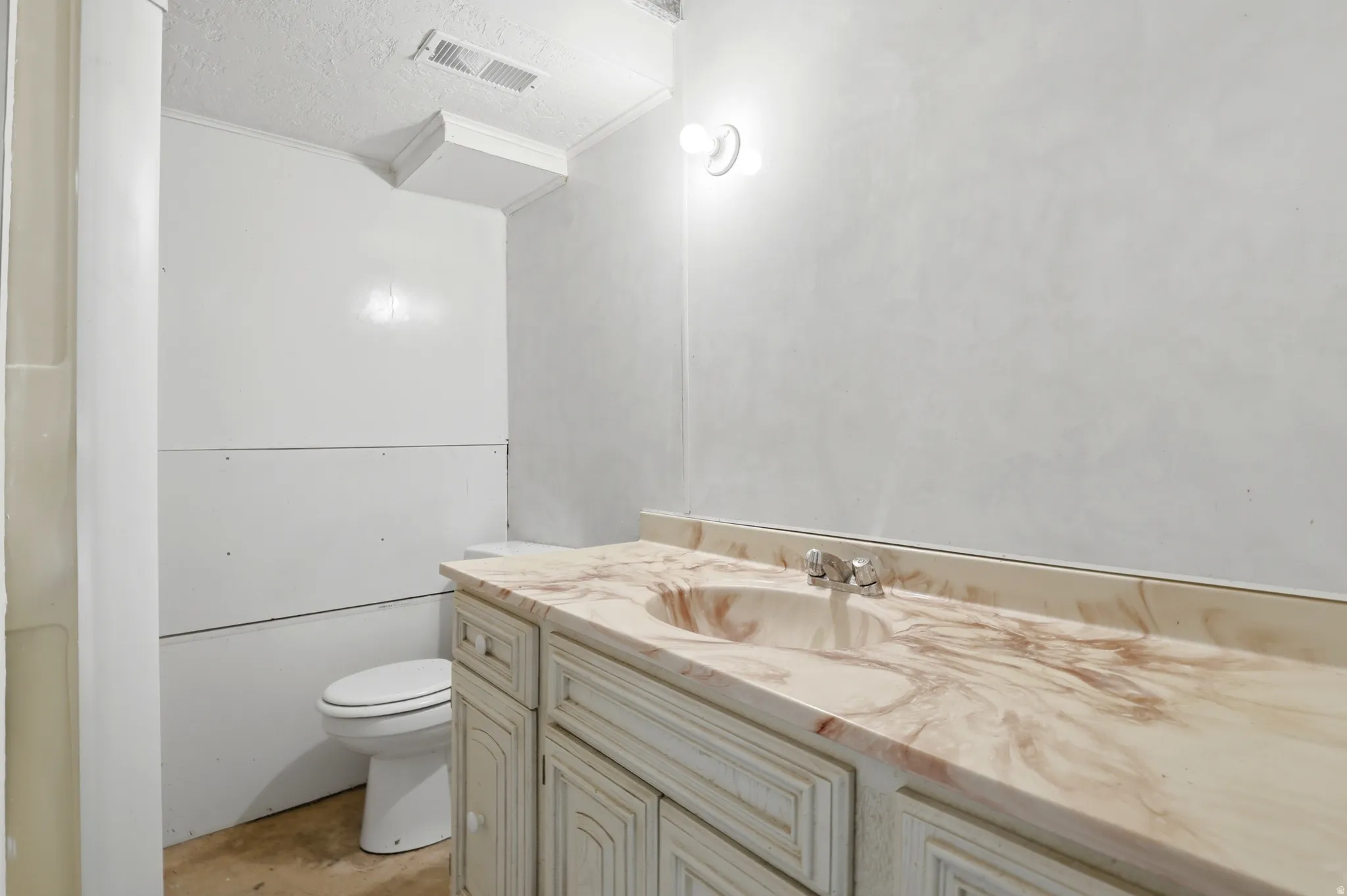 Bathroom vanity featuring a marbled countertop with an integrated sink and chrome faucet