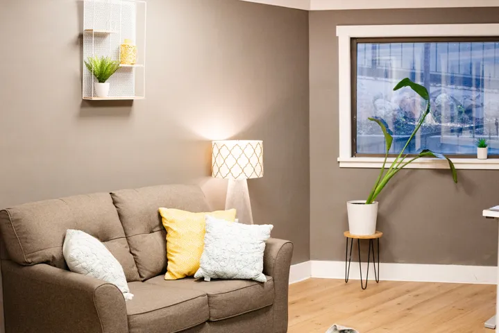 Neutral wall paint, light wood-finish flooring, and a large window with white trim