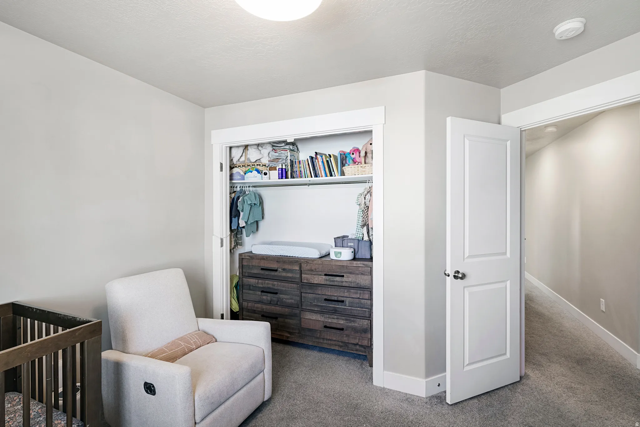 Carpeted interior space with a closet featuring built-in shelving