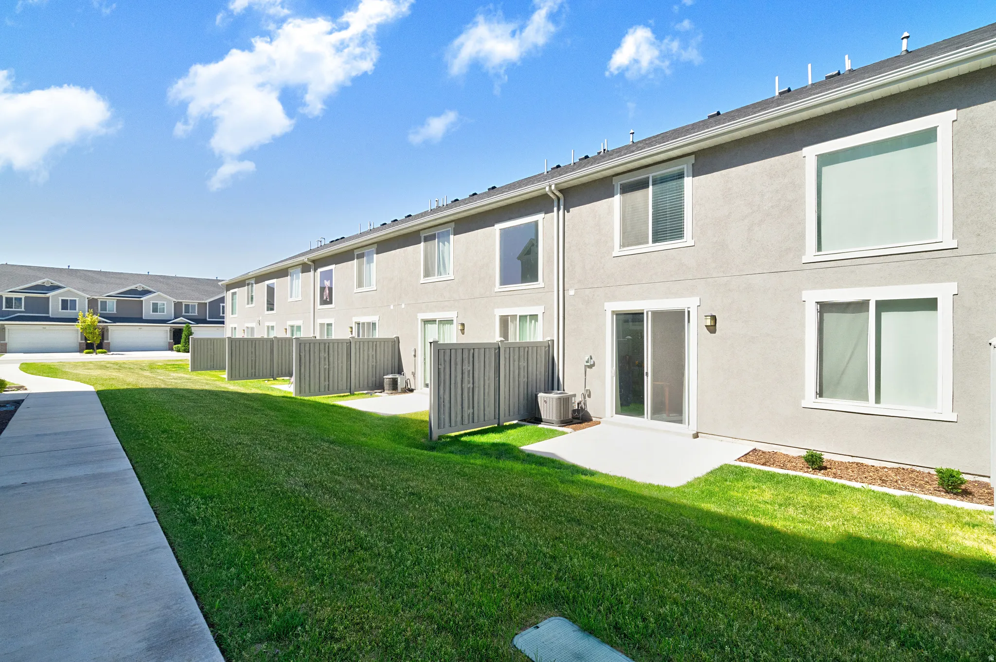 Rear exterior of townhome featuring a private patio area and sliding glass door access