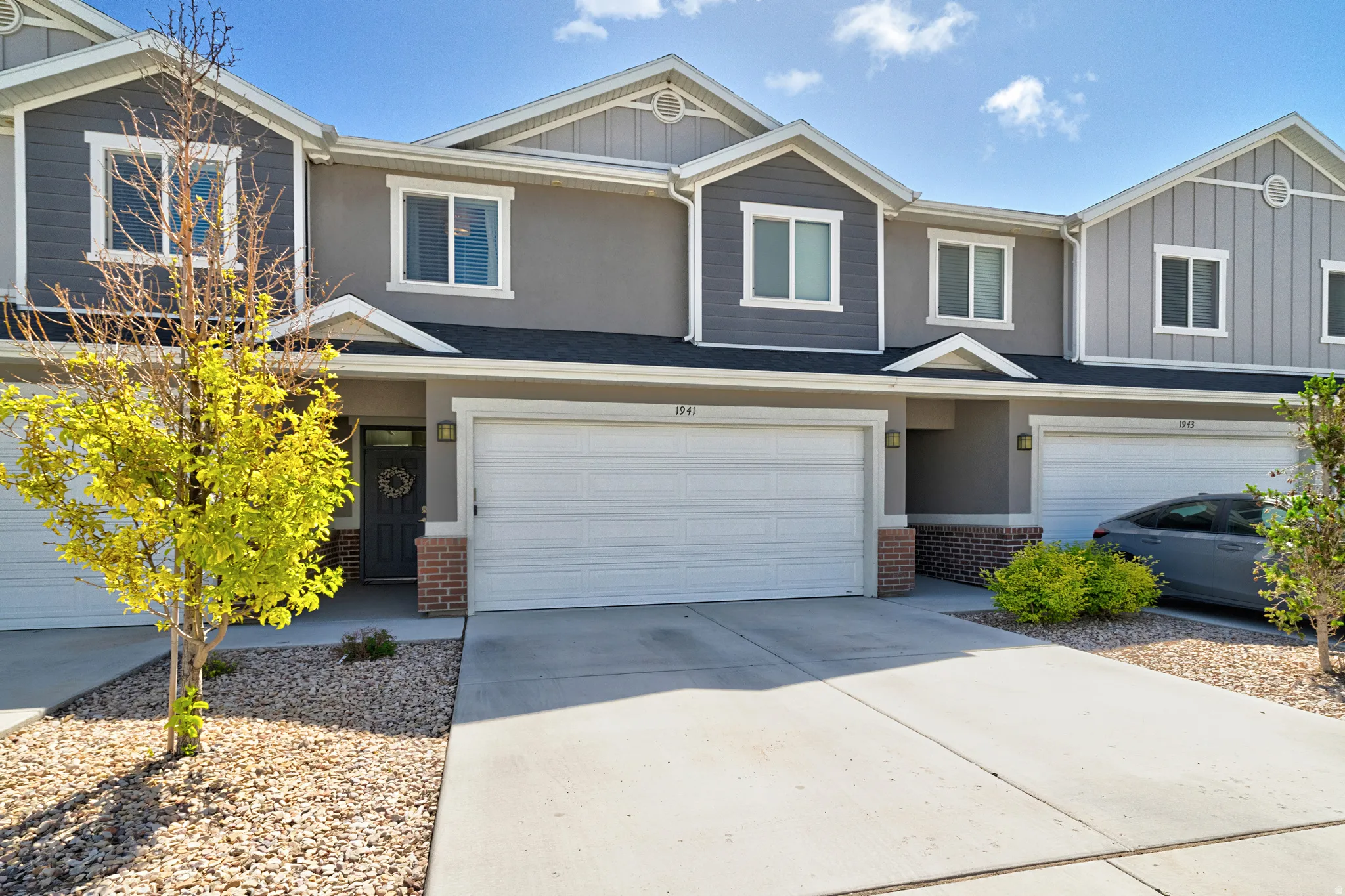 Modern townhouse exterior featuring mixed siding, white trim, a single-car garage, and an entry alcove