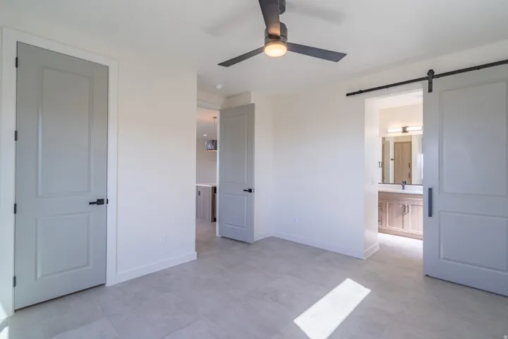 Spacious room featuring light-colored walls and large format tile flooring