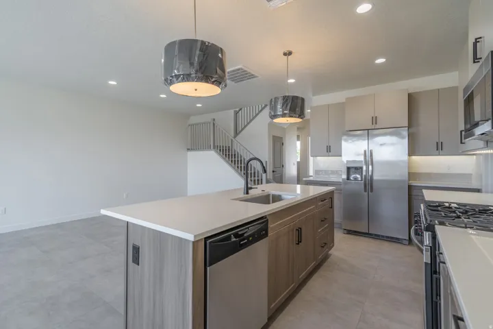 Modern kitchen featuring a large island with an undermount sink and integrated dishwasher