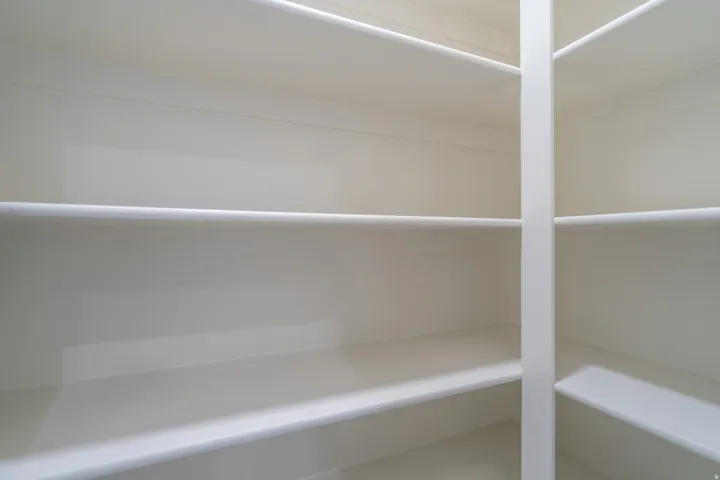 Expansive storage closet featuring multiple tiers of white shelving