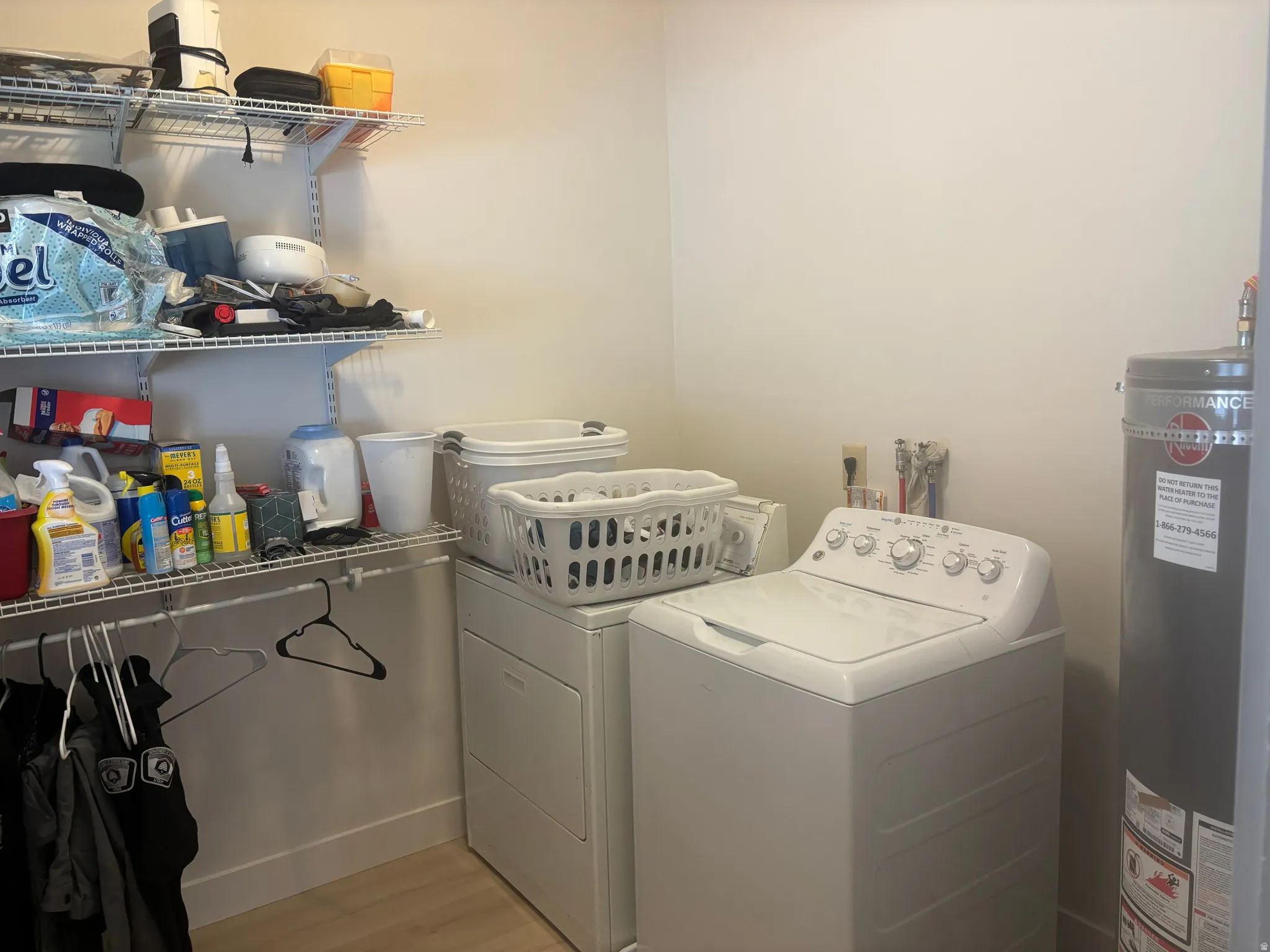 Dedicated laundry space featuring a white top-load washer, a white front-load dryer, and a grey water heater