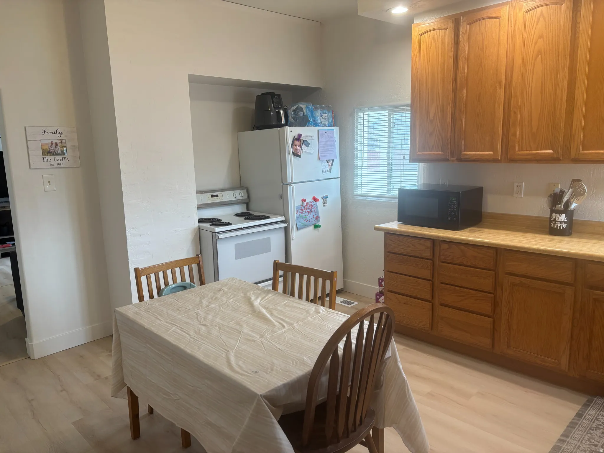 Kitchen area featuring wood-finish flooring, recessed lighting, and a window with horizontal blinds