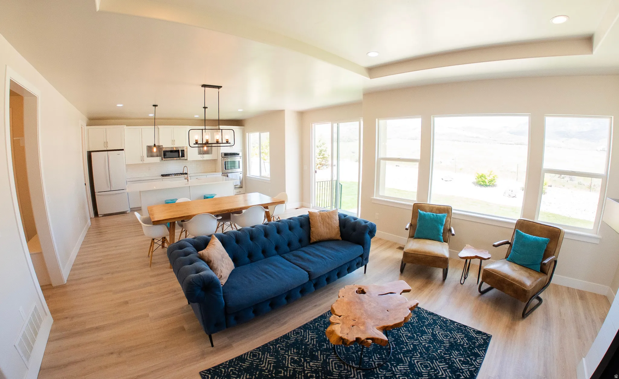 Open-concept living space featuring wood-finish flooring and abundant natural light