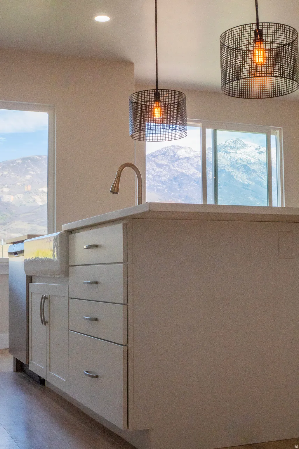 Kitchen island with white cabinetry and a farmhouse-style sink