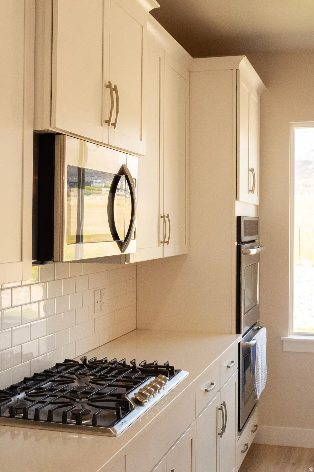Modern kitchen featuring a built-in microwave, gas cooktop, and double ovens