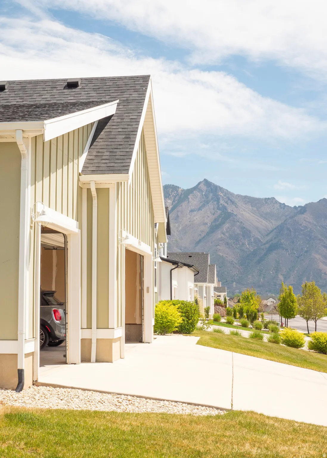 Gable-end architectural style featuring vertical siding and a dark shingle roof