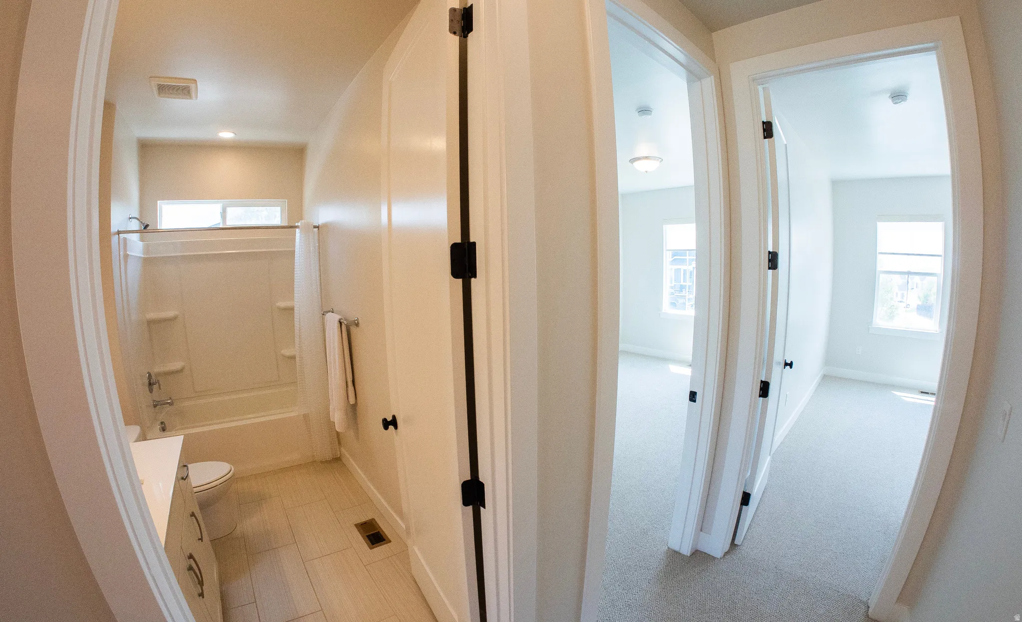Full bathroom featuring a white tub/shower combination, window above, and light-colored tile flooring